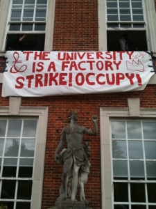banner that says: the university is a factory - strike, occupy!